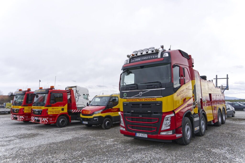 Holowanie ciężarówek Zgorzelec – holownik i lawety zaparkowane na firmowym placu